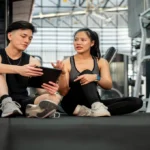 Delta Fitness Authority expert trainer showing fitness results on tablet