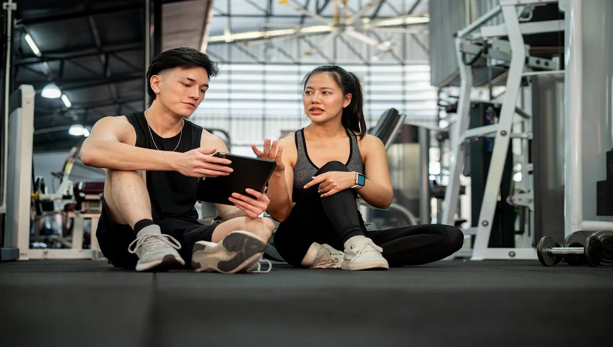 Delta Fitness Authority expert trainer showing fitness results on tablet