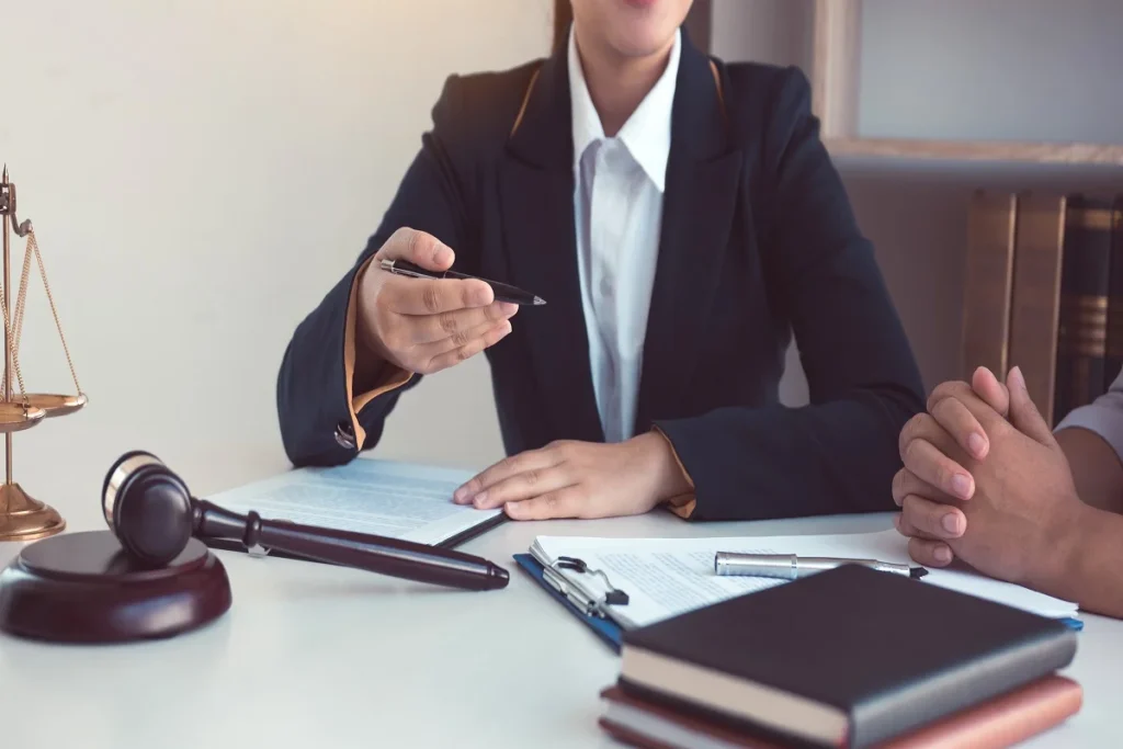 A professional business lawyer reviewing corporate contracts and legal compliance documents at a modern office desk.